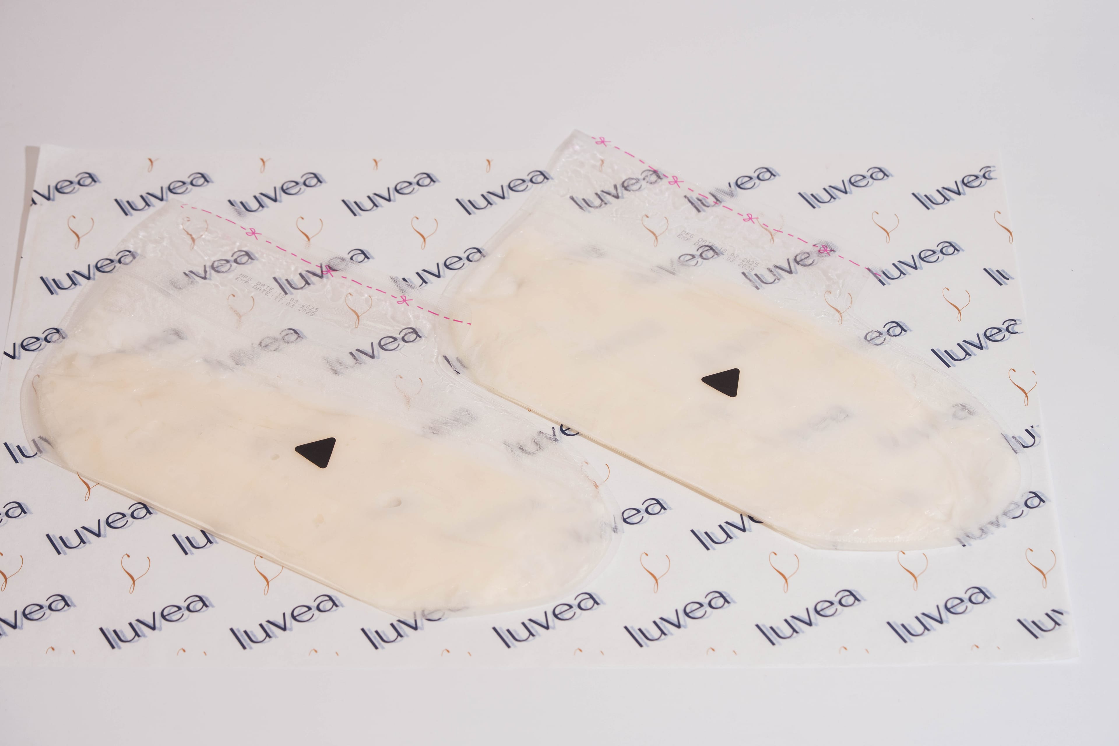 Pair of bootie-shaped paraffin wax masks arranged on luvéa branded paper
